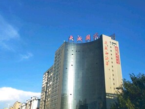 A high-rise building with a curved facade and a prominent sign at the top. - Tiancheng Hotel (Yuanjiang)