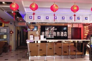 A hotel lobby with a reception desk, red lanterns, and a sign indicating it is a hotel. - Deli Business Hotel (Baicheng)