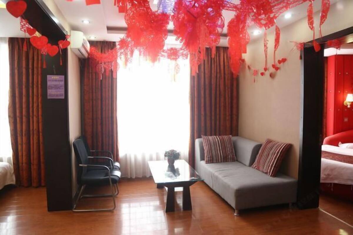 A hotel room with a sofa, a chair, a small table, and a bed.