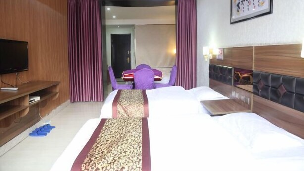 Une chambre d’hôtel avec un grand lit, une télévision, un bureau et une chaise.