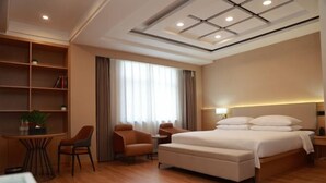 Une chambre d’hôtel moderne, dotée d’un grand lit, d’un bureau, d’une chaise, d’une bibliothèque et d’une fenêtre avec des rideaux.