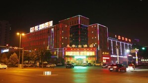 Un hôtel à plusieurs étages, doté d’une enseigne lumineuse et d’une entrée imposante.