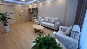 Un salon moderne avec un canapé, une table basse et une plante en pot.