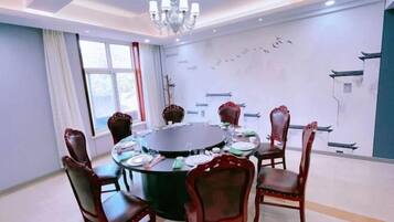A conference room with a round table, six chairs, and a chandelier.