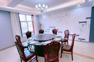 Un salón de conferencias con una mesa redonda, seis sillas y una araña.