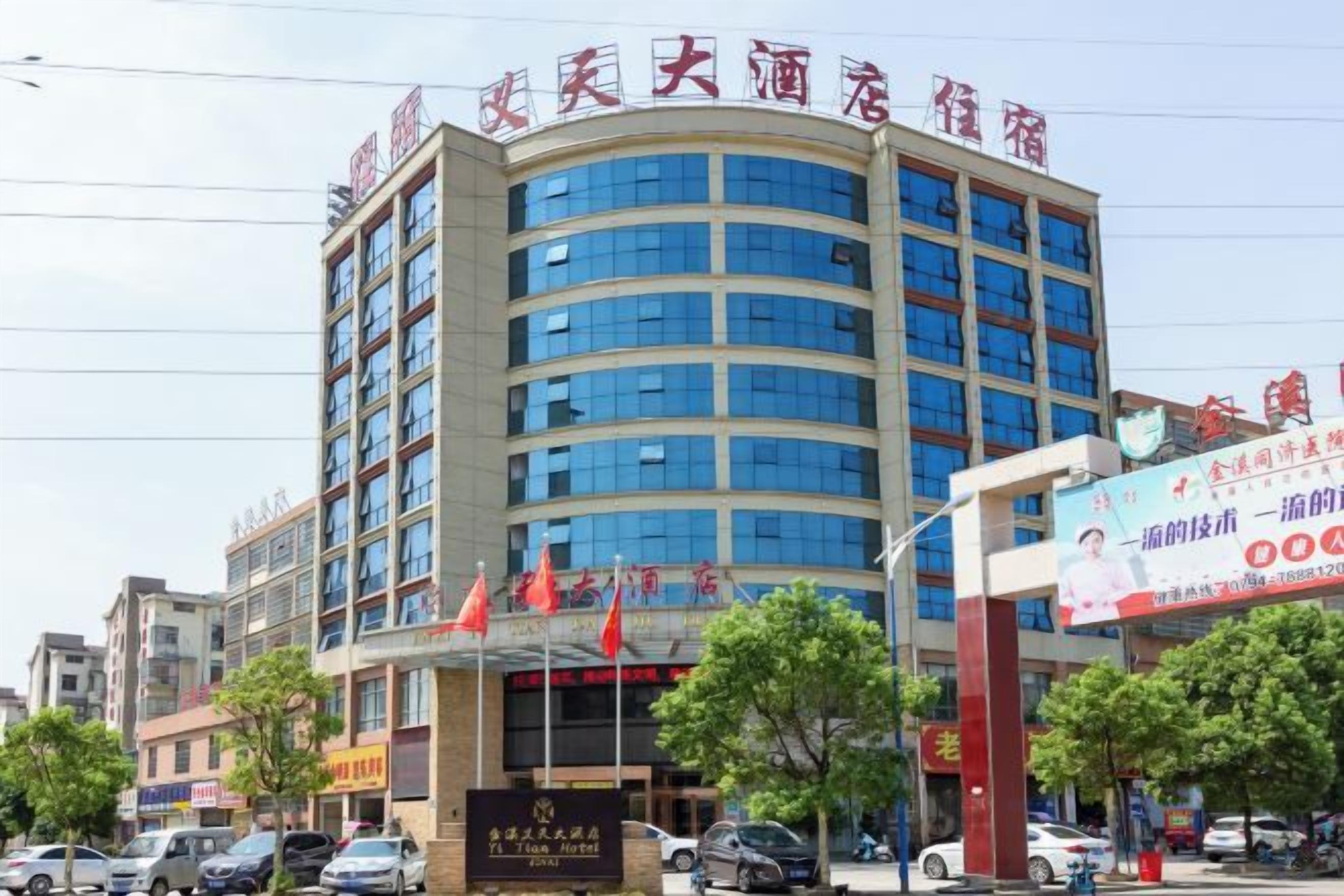 A multi-story hotel with a curved facade, multiple windows, and a prominent entrance with flags.