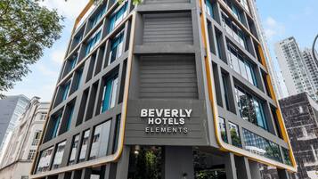Een modern hotelgebouw met een bord waarop staat: BEVERLY HOTELS ELEMENTS.