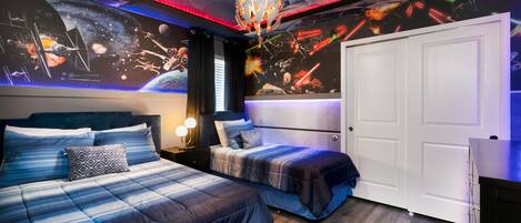 A bedroom with two beds, a ceiling mural of space scenes, and a modern chandelier.