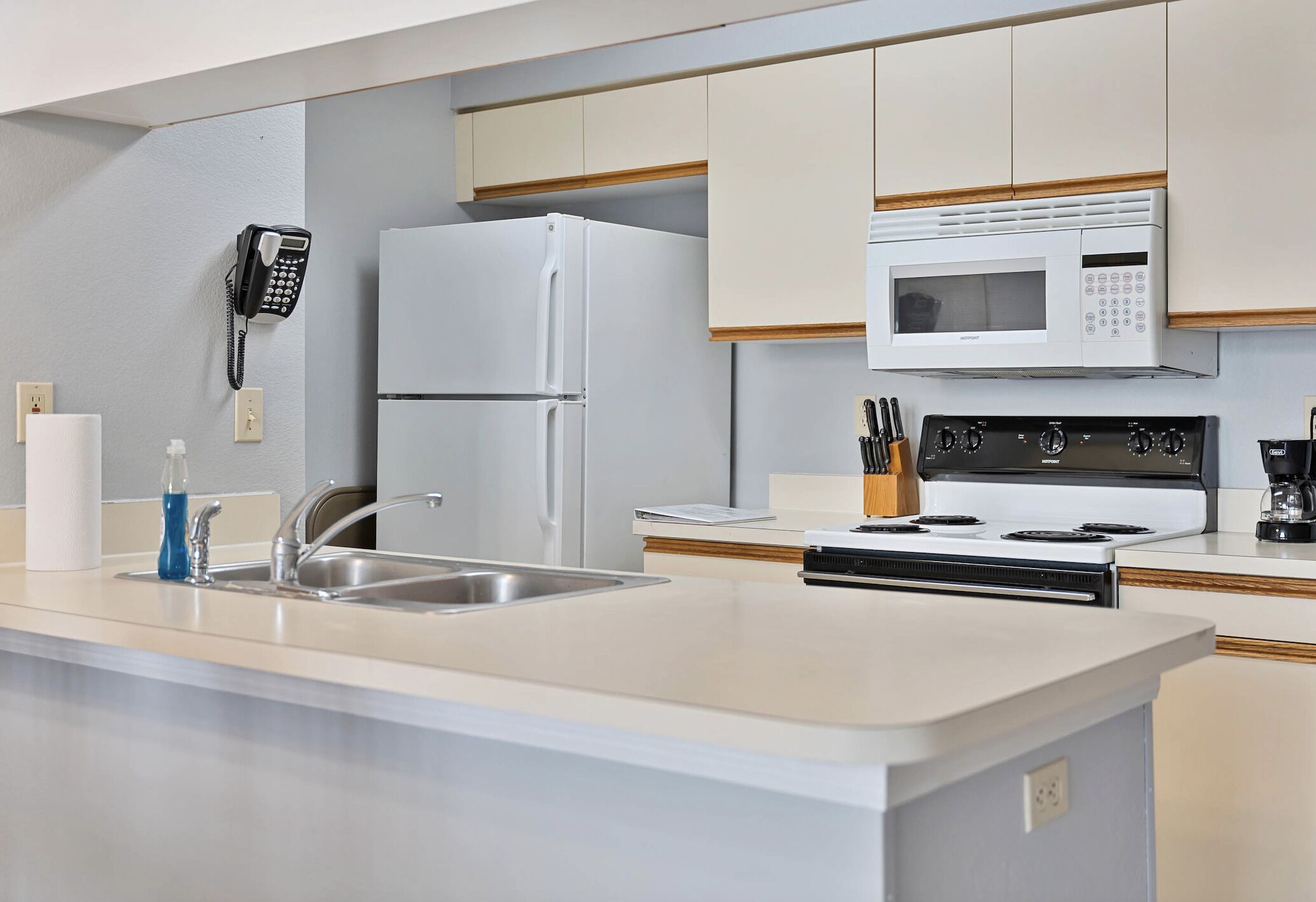 A modern kitchen with a built-in refrigerator, microwave, stove, and sink.