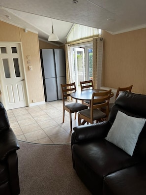 Cozy living space with a dining area and seating area, featuring a modern kitchen and comfortable sofa.