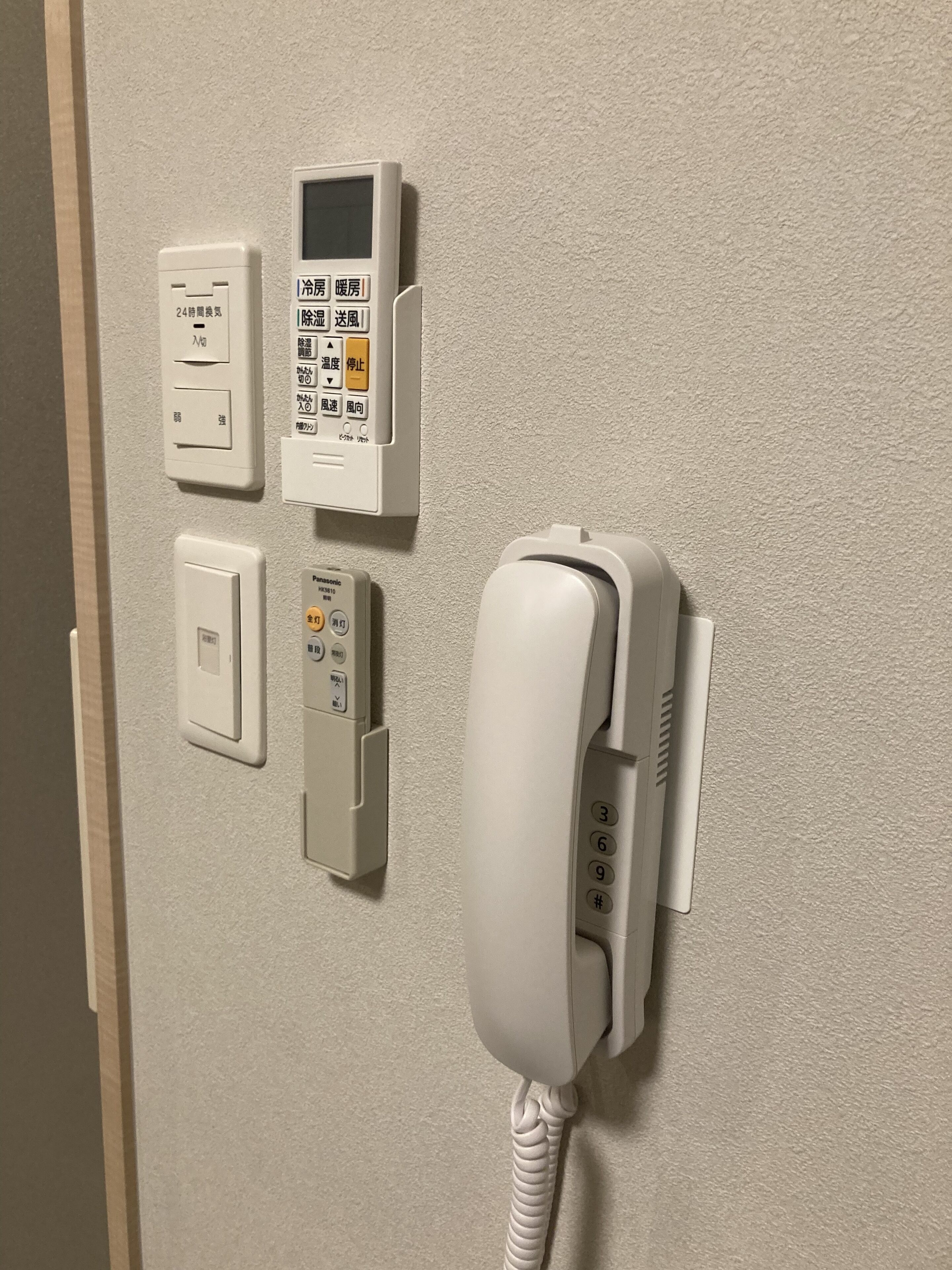 Ein fest installiertes Telefon, ein Thermostat und eine Steckdose.
