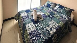 A bedroom with a bed, a window, and decorative wall pieces. - 5 km from the Coffee Park! - Montenegro LOFT with swimming pool in Quindio - (Montenegro)
