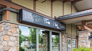 A hotel entrance with a stone facade, a sign indicating room numbers and types, and a covered entrance area. - 3-bedroom Daily Monthly Rates Available Unit 3 (Parksville)
