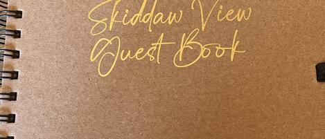 En spiralbunden anteckningsbok med texten ”Fiddaw View Guest Book” tryckt på omslaget.