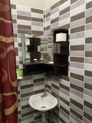 A bathroom with a white sink, a mirror, and a towel holder.