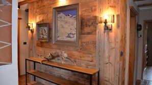 A wooden wall with framed artwork and wall-mounted lighting. - Appartement  Streifblick
Wohlfühlappartement für bis zu 6 Personen   (Kitzbühel)