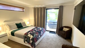 A hotel room with a bed, a chair, a desk, and a large window with curtains. - Baudins Bed & Breakfast - Adults Only (West Busselton)