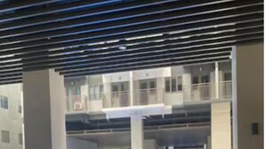 Una piscina interior moderna con superficie de agua azul cristalina, rodeada por un solado de baldosas y paredes de hormigón.