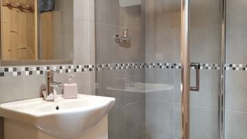 Een douche, een haardroger, handdoeken, toiletpapier