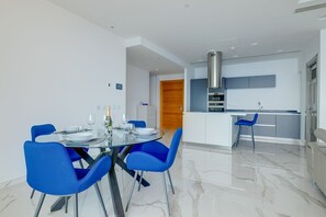 A modern kitchen with a stainless steel range hood, a built-in oven, and a white countertop. - Super Luxury Apartment in Tigne Point, Amazing Sea Views (Sliema)