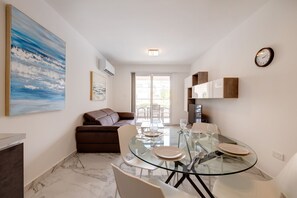 Ein modernes Wohnzimmer mit einem Glastisch, einem braunen Sofa und einem großen abstrakten Gemälde.