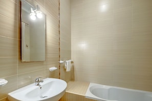 A bathroom with a sink, mirror, and bathtub. - Modern 2 Bedroom Maisonette in Central Sliema (Gzira)