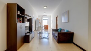 Ein modernes Wohnzimmer mit einer Couch, einem Couchtisch und einem Essbereich mit Stühlen und einem Tisch.
