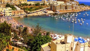A coastal town with a marina, beach, and historic buildings. - Duplex Luxury Apartment in Portomaso With Pool (St. Julian's)