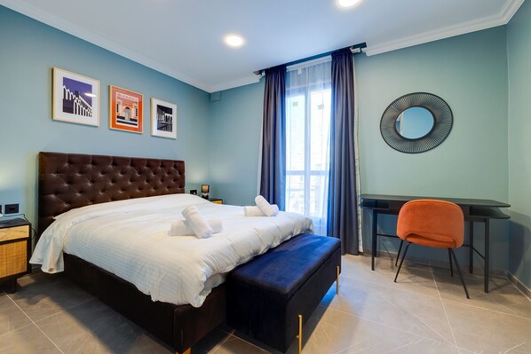 Une chambre avec un grand lit, un bureau et une chaise.