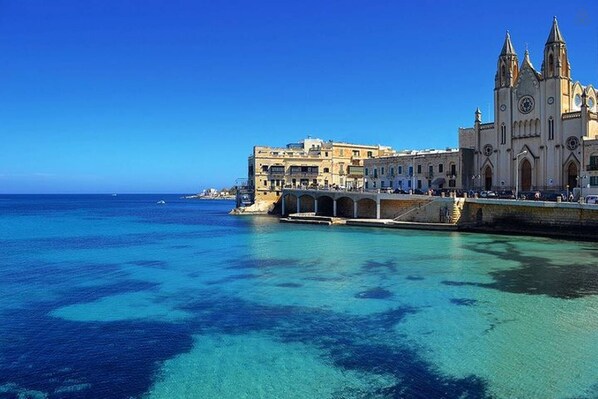 A coastal town with a prominent church and a bridge leading to a waterfront area.
