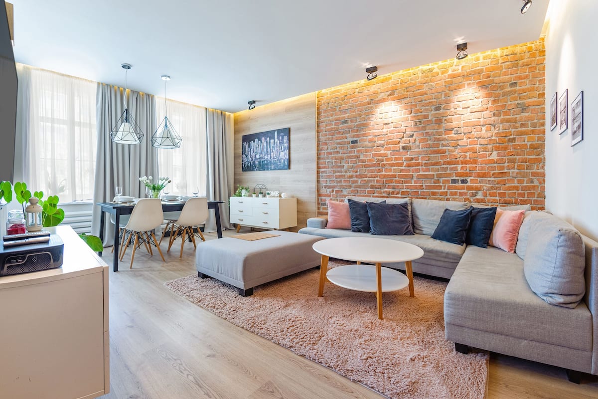 A modern living room with a sofa, coffee table, and dining area.