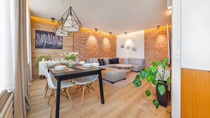 Een moderne woonruimte met een eethoek, een bank en een metselwerk muur.