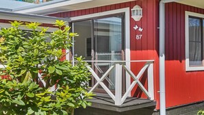 Un bâtiment rouge avec une porte blanche, le numéro 87, et un petit balcon doté d’une balustrade.