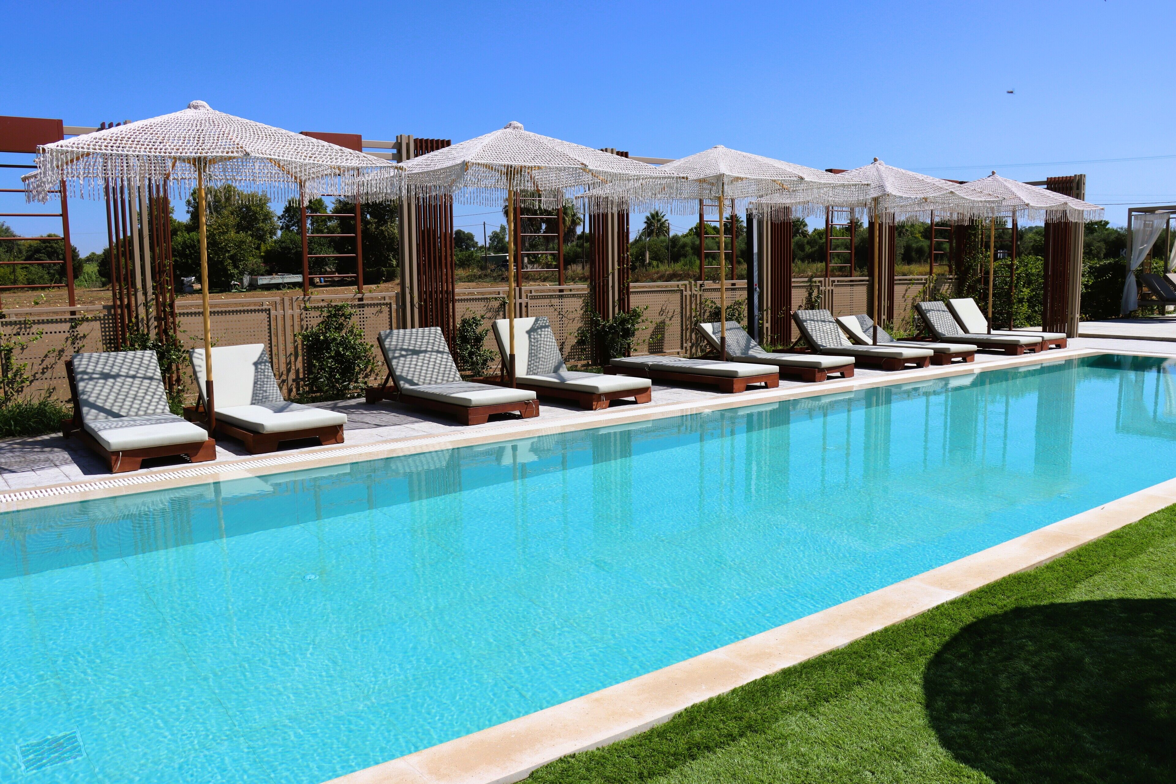 A swimming pool with lounge chairs and umbrellas.