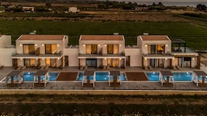 Una vila moderna amb piscina, diversos balcons i vista al camp.