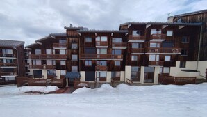 Ein mehrstöckiges Holzgebäude mit Balkonen, umgeben von Schnee.