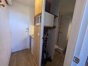 A compact kitchen with a microwave, a small sink, and wooden cabinets.