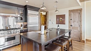 A modern kitchen with a central island, stainless steel appliances, and pendant lighting.