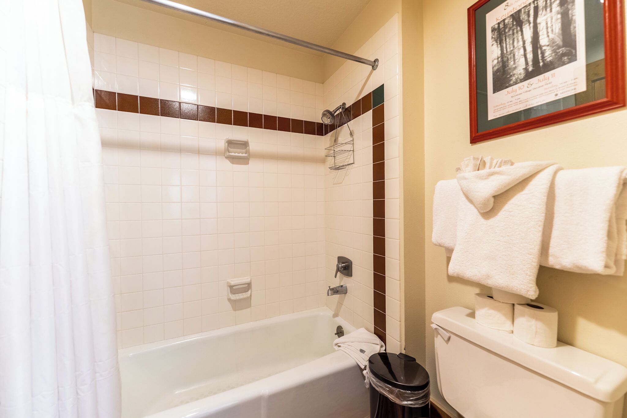 A bathroom with a bathtub, toilet, and a towel rack.