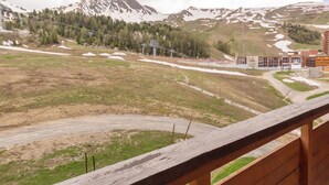 A mountainous landscape with a road, buildings, and a wooden fence. - Bright studio with balcony at the foot of Plagne Centre slopes (La Plagne)