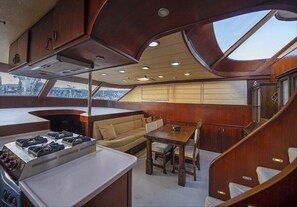 Enjoy a modern space with a gas stove, dining table, and sofa, perfect for casual meals and relaxation.