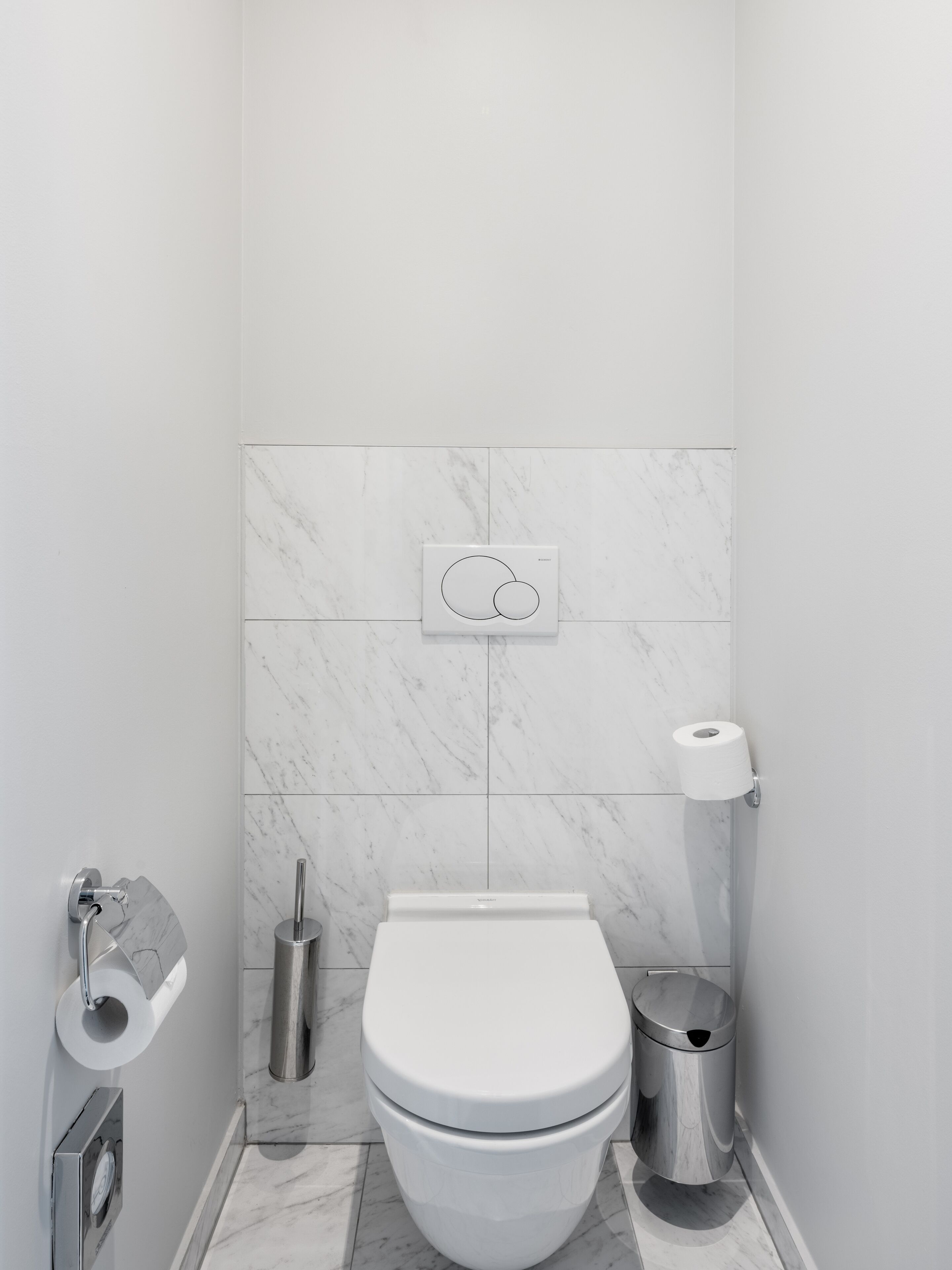 Une salle de bain moderne équipée de toilettes, d’un bidet et d’une poubelle.