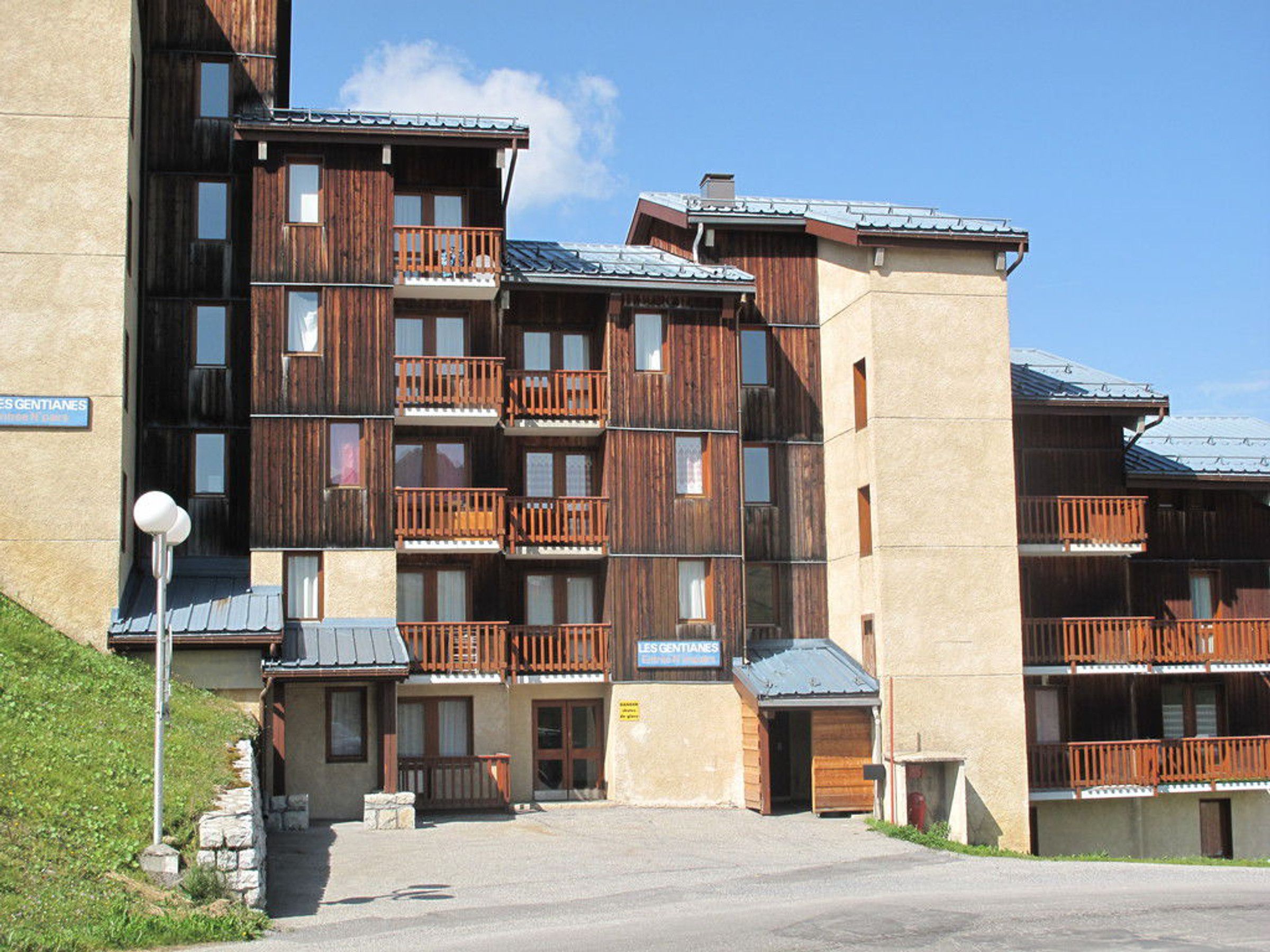 A multi-story hotel with wooden balconies and a stone facade.