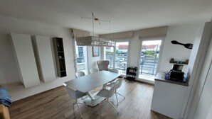 A modern kitchen with a dining area, large windows, and a view of the outside.