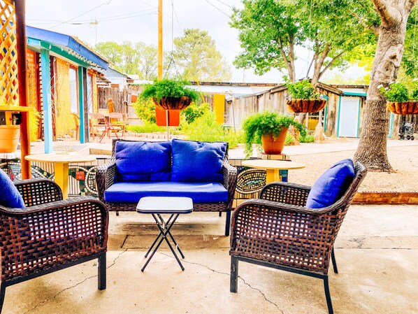 An outdoor seating area with wicker furniture and a blue sofa.