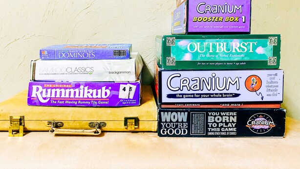 A stack of board games on a suitcase.