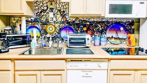 Una cocina equipada con microondas, tostadora, pileta y lavavajillas.