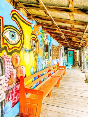 A wooden bench and a colorful mural with abstract designs. - Santa Fe - Inn at the Art Center (San Angelo)