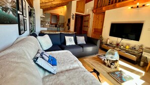 A cozy living room with a sofa, coffee table, and a TV.