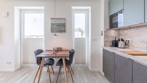 A modern kitchen with grey cabinets, a wooden countertop, and a built-in oven.